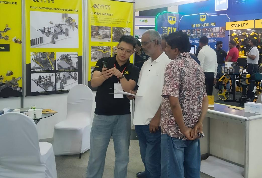 The Qunfeng Machinery team demonstrates the advantages of the intelligent block-making machine to an Indian client. A equipe da Qunfeng Machinery demonstra as vantagens da máquina inteligente de fabricação de blocos para um cliente indiano.