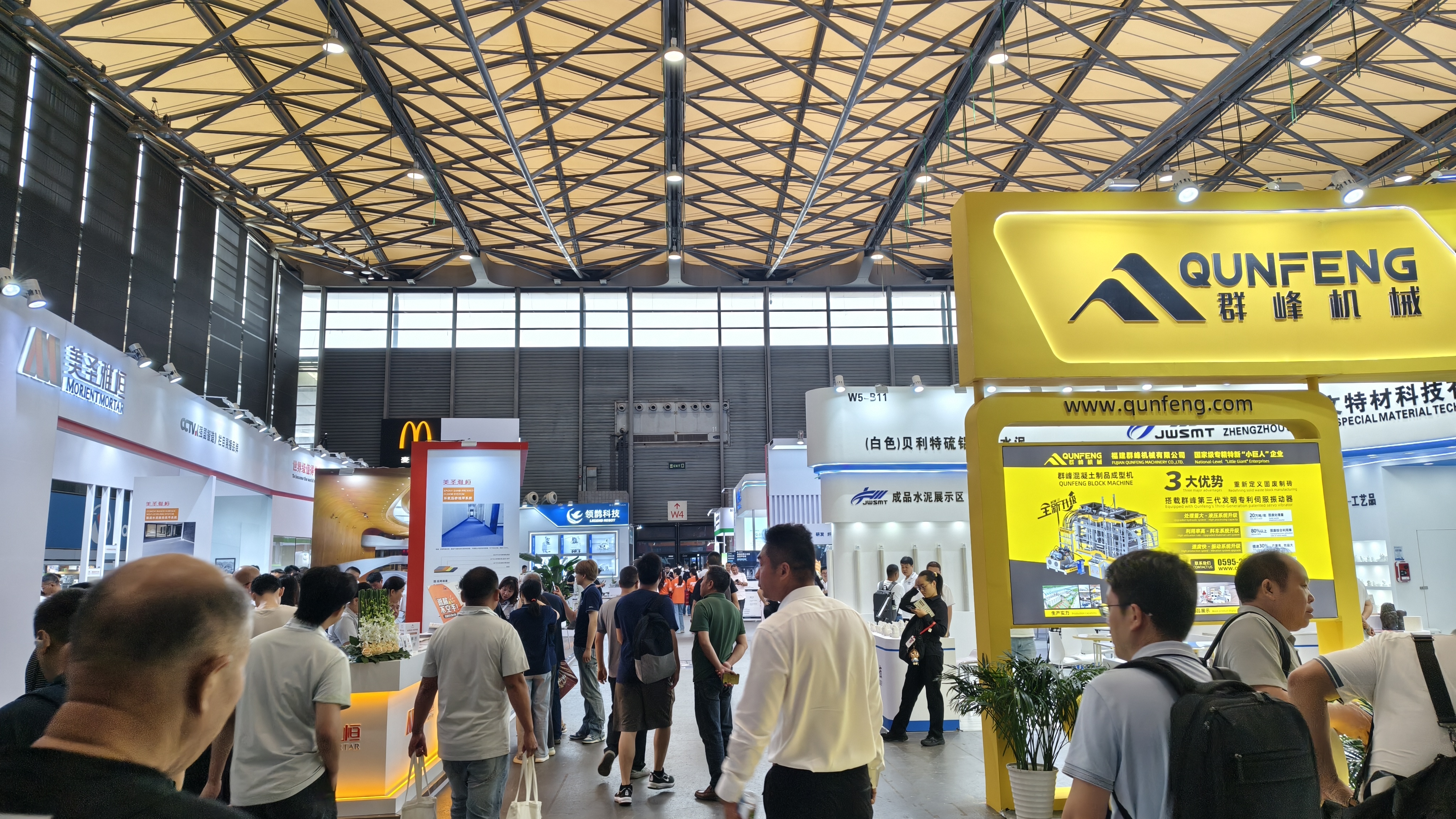 Qunfeng Machinery’s booth draws crowds, making it the hottest brand in the block-making machine industry. O estande da Qunfeng Machinery atrai multidões, tornando-a a marca mais popular na indústria de máquinas para fabricação de blocos.