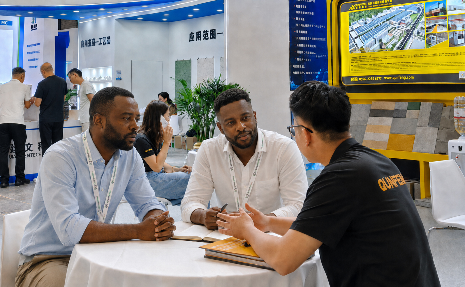 African clients listen attentively as the Qunfeng Machinery team gives a presentation; they show great interest in Qunfeng’s intelligent block-making machines. Os clientes africanos ouvem atentamente enquanto a equipe da Qunfeng Machinery faz uma apresentação; eles mostram grande interesse nas máquinas inteligentes de fabricação de blocos da Qunfeng.